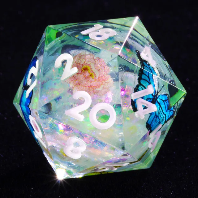 Close-up of a transparent D20 with white numbers, a blue butterfly and a pink flower.