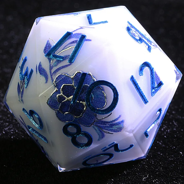 Close-up of a white D20 with metallic blue numbers and a purple flower.