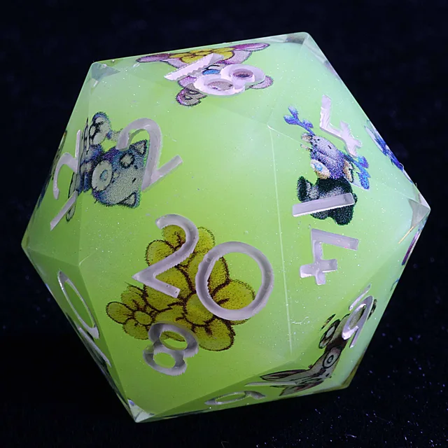 Close-up of a pale green D20 with animal illustrations, a yellow flower and pale numerals.