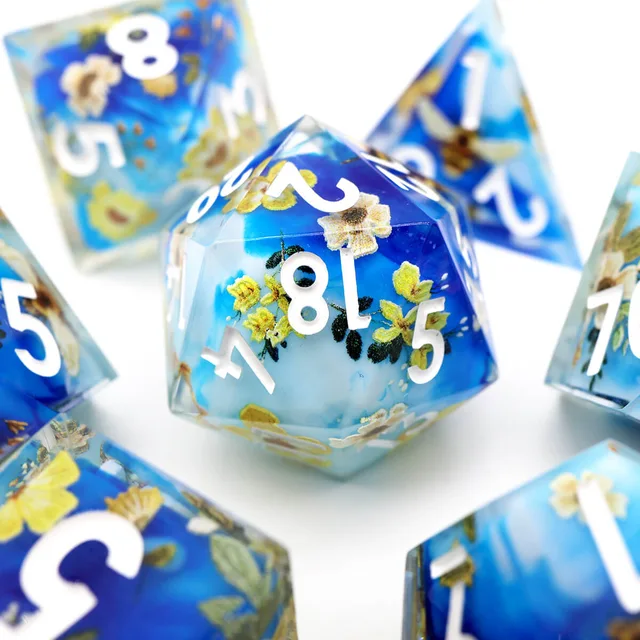 Close-up of a blue floral D20 with white numbers.