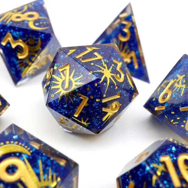 Deep-blue glitter resin D20 decorated with gold sunbursts, stars and gold numbers.