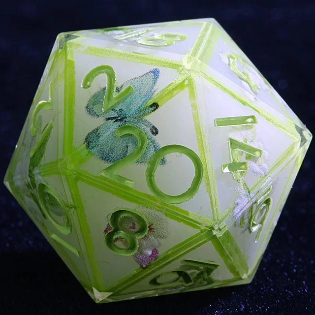 Close-up of a pale translucent D20 with green numbers and a blue butterfly.