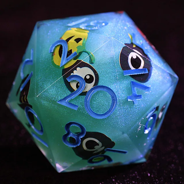 Close-up of a shimmering blue-green D20 with blue numbers and cartoon ghost illustrations.