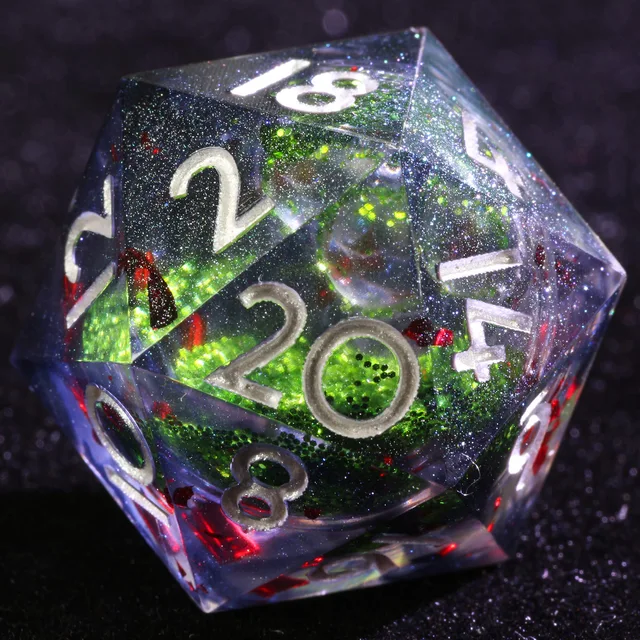 Close-up of a clear D20 with a glittering green centre, red flakes and silver-coloured numbers.