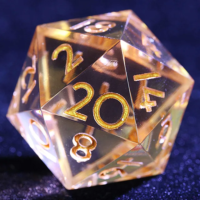 Close-up of a transparent amber-gold D20 with gold-coloured numbers.