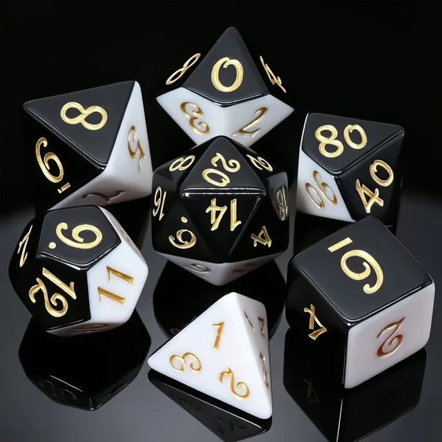 Glossy black-and-white polyhedral dice with gold-coloured numerals on a black playmat.