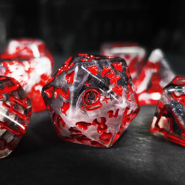 Clear to smoky translucent polyhedral dice with cloudy white and dark swirls, bright red numbers and red decorative symbols on a black playmat