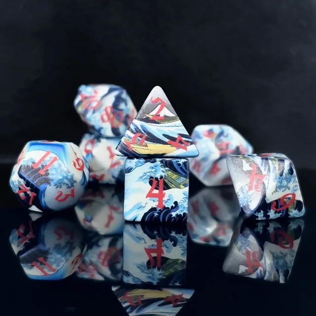 White dice with blue and black wave-like artwork, green and yellow accents, and red numerals.