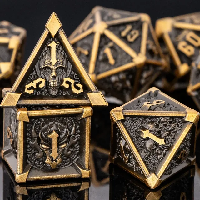 Dark charcoal-black polyhedral dice with antique-gold edges, raised numbers and recessed skull, dragon-head and swirling motifs.